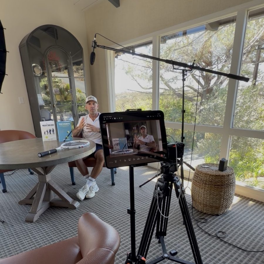 Behind the scenes of an interview setup with camera, monitor and boom mic